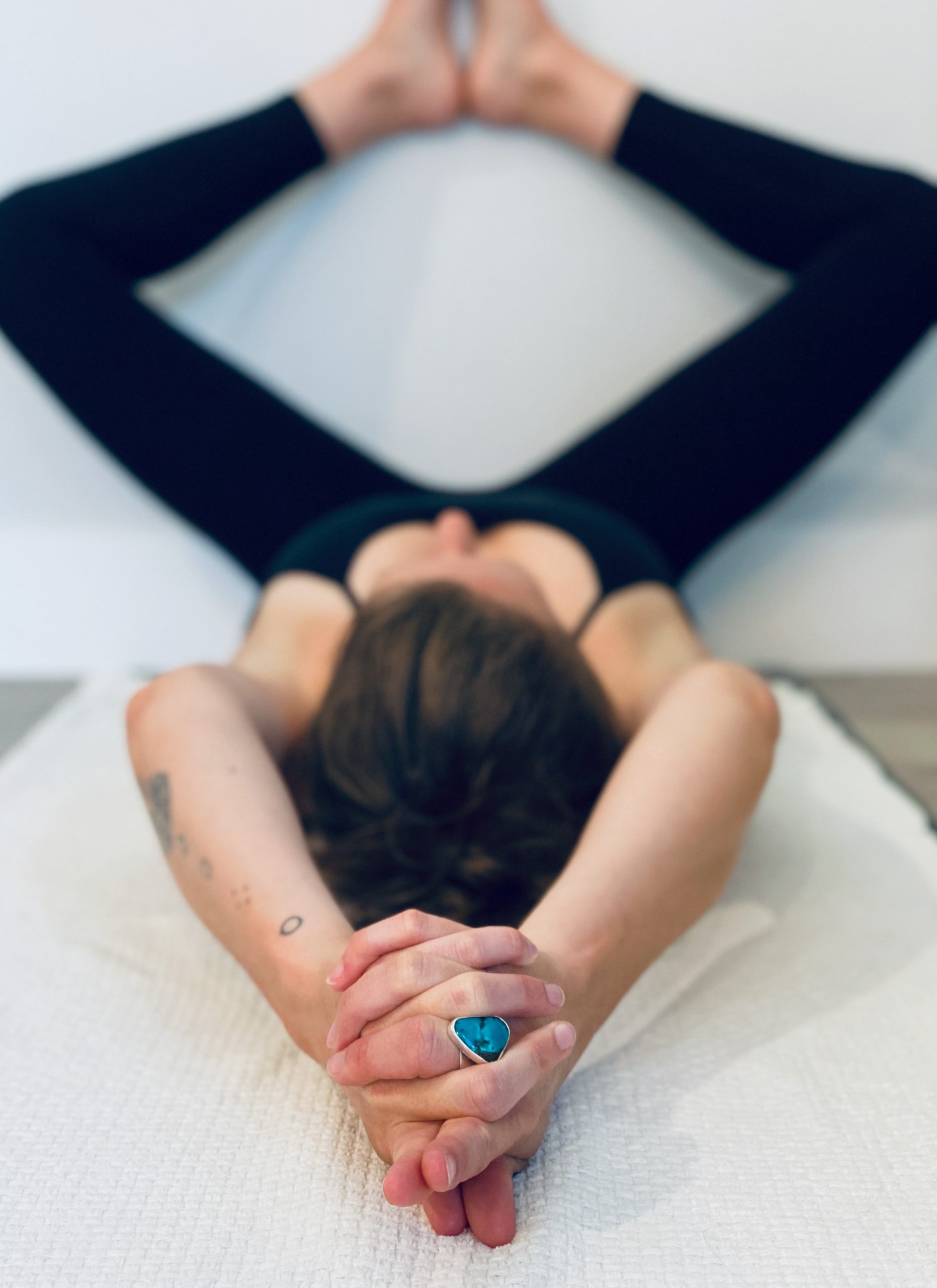 Mujer Joven En Mono En Posición De Yoga Con Las Piernas Cruzadas